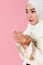 Portrait of young and cute Asian Islamic woman rise hands in praying gesture in calm and concentrate manner