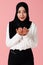 Portrait of young and cute Asian Islamic woman rise hands in praying gesture in calm and concentrate manner