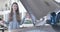 Portrait of young desperate Caucasian woman standing next to open car hood and shaking head. Beautiful stressed girl