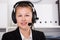 Portrait of young dispatcher in black suit which is talking by headset with client