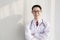 Portrait of young doctor with stethoscope office wall background.