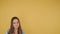 Portrait of a young dreaming woman on yellow background isolated. Woman looks up on free space