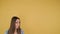 Portrait of a young dreaming woman on yellow background isolated. Woman looks up on free space