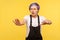 Portrait of young embarrassed woman walking with outstretched hands to find way. yellow background, studio shot