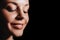 Portrait of a young European girl close-up on a black background in the evening light, close-up of a beautiful girl`s face.