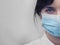 Portrait of a young European woman in a protective disposable medical mask. Concept of caronavirus Cavid 19 and human quarantine.