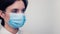 Portrait of a young European woman in a protective disposable medical mask. Concept of caronavirus Cavid 19 and human quarantine.