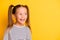 Portrait of young excited curious happy smiling girl child kid look in copyspace  on yellow color background