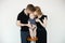 Portrait of young family in dark clothes with plump cherubic baby infant toddler standing, kissing on white background.