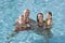 Portrait of young family smiling in swimming pool