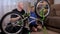 Portrait of a young father and his son repair a broken bicycle together at home.