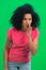 Portrait of young female African American covering her mouth with her hand and whispering the secret. Black woman with