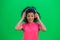 Portrait of young female African American enjoying music in big white headphones. Black woman with curly hair in pink