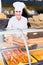 Portrait of young female bakers with tasty bread with fish smiling in bakery