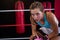 Portrait of young female boxer sitting at corner