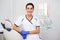 Portrait of young female dentist posing in dental clinic