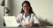 Portrait of young female physician in uniform sit at desk