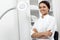 Portrait of a young female professional cosmetologist with bright smile in cosmetology cabinet.