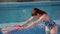 Portrait of young female swimming coach while working with children in the pool.