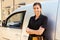 Portrait of young female trade worker standing by a van