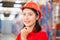 Portrait of young female warehouse worker standing in warehouse, Smiling woman in hard hat looking at camera at warehouse, Worker