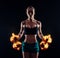 Portrait of a young fitness woman in sportswear doing workout with fiery dumbbells on black background. Tanned athletic girl.