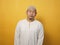 Portrait of young funny attractive Asian muslim man showing lazy disgust unhappy bored mocking expression, against yellow