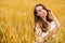 Portrait of a young girl on a background of golden wheat field