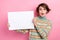 Portrait of young girl black friday purchase shopaholic holding paper promo billboard shock speechless isolated on pink
