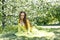 Portrait of a young girl among the branches of a flowering apple