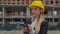 Portrait of a young girl in a business engineer insuit and a yellow hard construction hat. female on the background of