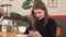 Portrait of a young girl in a cafe with a latte and a phone in his hands.