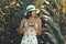 Portrait of a young girl in flowery white dress and hat taking photos with a vintage camera