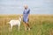 Portrait of a young girl with a goat in a wheat fieldess