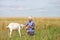 Portrait of a young girl with a goat in a wheat fieldess