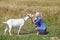 Portrait of a young girl with a goat in a wheat fieldess