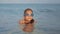 Portrait of young girl in water mask relaxing in sea water. Child enjoying rest