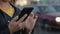 Portrait of a young girl who stands in the city, in her hands a smartphone, mobile phone