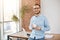 Portrait of young good-looking bearded entrepreneur in glasses and casual clothes, standing in bright coworking office