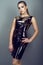 Portrait of young gorgeous slender model with ponytail and artistic make-up wearing tight-fitting sequin golden dress