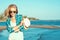 Portrait of young gorgeous suntanned blond wearing mirrored heart shaped sunglasses and checked blue shirt at the seaside