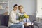 Portrait of young grownup daughter with flower embracing elderly mother