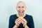 Portrait of a young handsome bald man holding a high-calorie big burger in his hands. concept of diet, unhealthy and