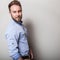 Portrait of young handsome friendly man in blue shirt. Studio photo on light grey background