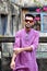 Portrait of a young and handsome Indian Bengali man standing in front of a vintage house wearing green Indian traditional Punjabi