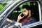 Portrait of young handsome indian man driving car and speaking on mobile phone