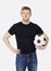 Portrait of a young handsome man in casual wear holding soccer ball over white background