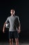 portrait of a young handsome soccer player man on a street playing with a football ball.