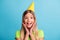 Portrait of young happy excited shocked amazed girl hold hands cheeks wear cone cap  on blue color background