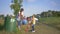 Portrait of young happy family of activist with kid girl collects refuse in trash bag while cleaning nature from plastic